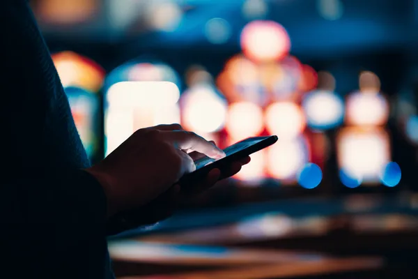 Uma mulher elegante ao lado de máquinas caça-níqueis vibrantes exibindo setes brilhantes, mostrando a variedade de slots no 5YYY.